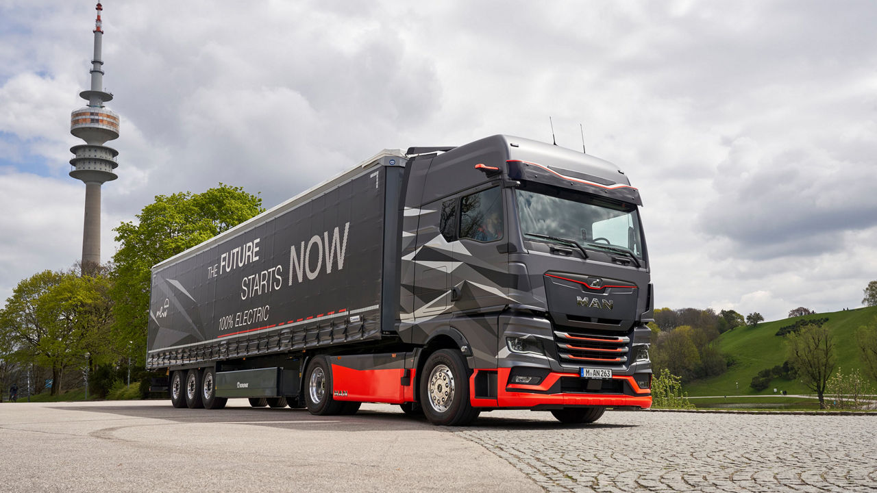 The new eTruck is on the grounds of the Olympic grounds. In the background the TV tower and green hills. 