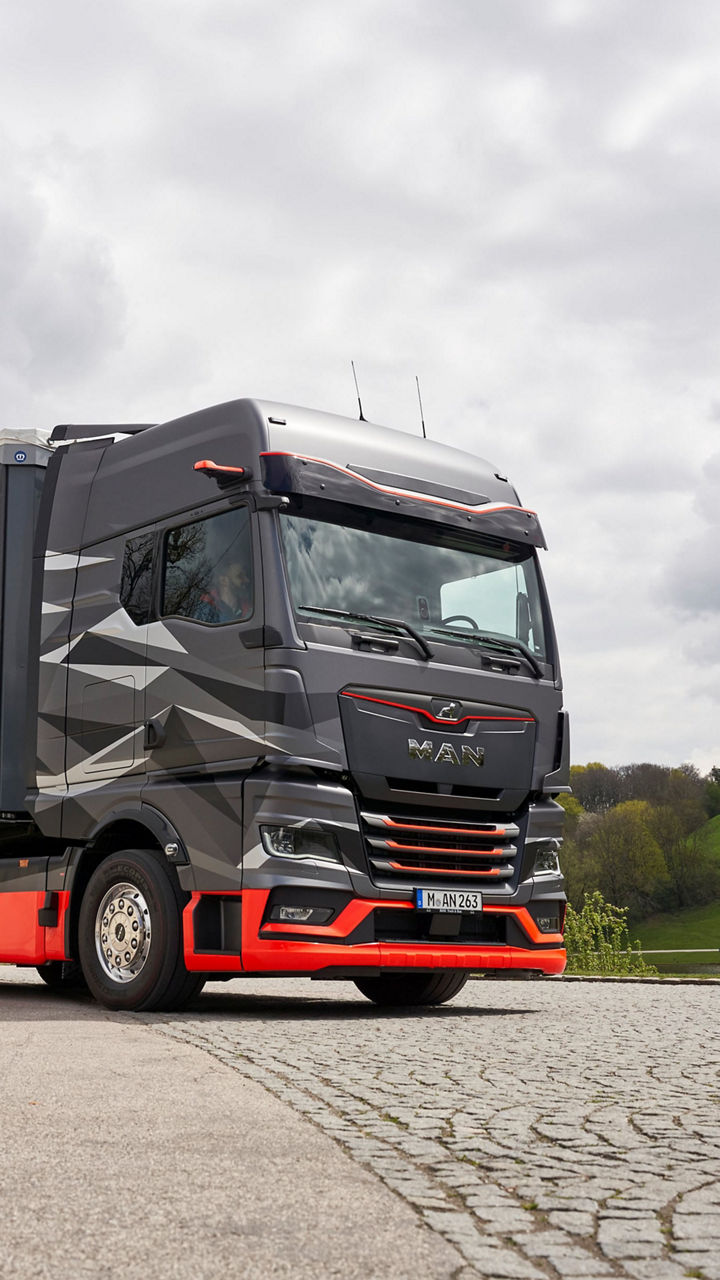The new eTruck is on the grounds of the Olympic grounds. In the background the TV tower and green hills. 