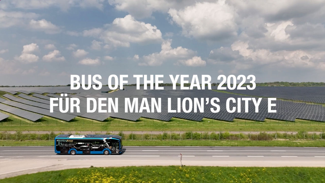 The MAN Lion's City E on the street next to a solar field.