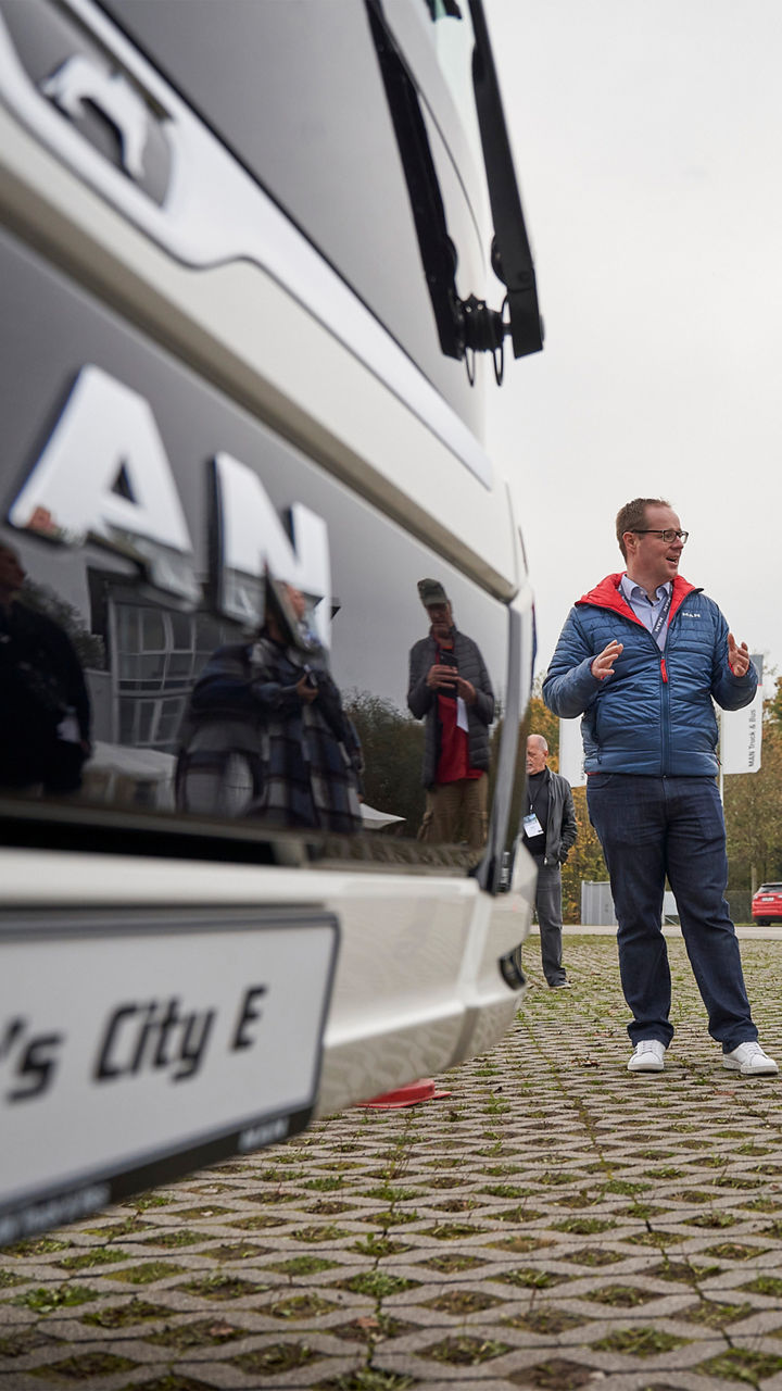 Journalisten und Journalistinnen stehen auf dem MAN Testgelände und schreiben etwas auf