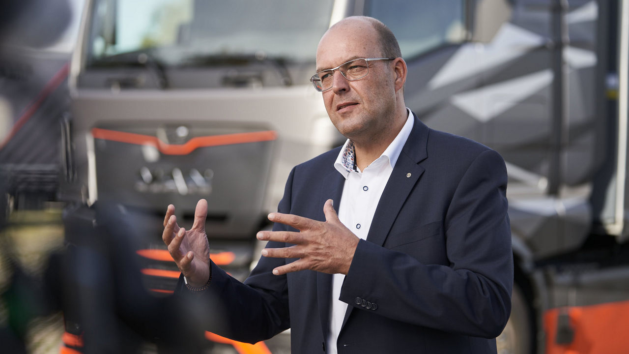 Bernd Reining steht vor dem eTruck und gestikuliert