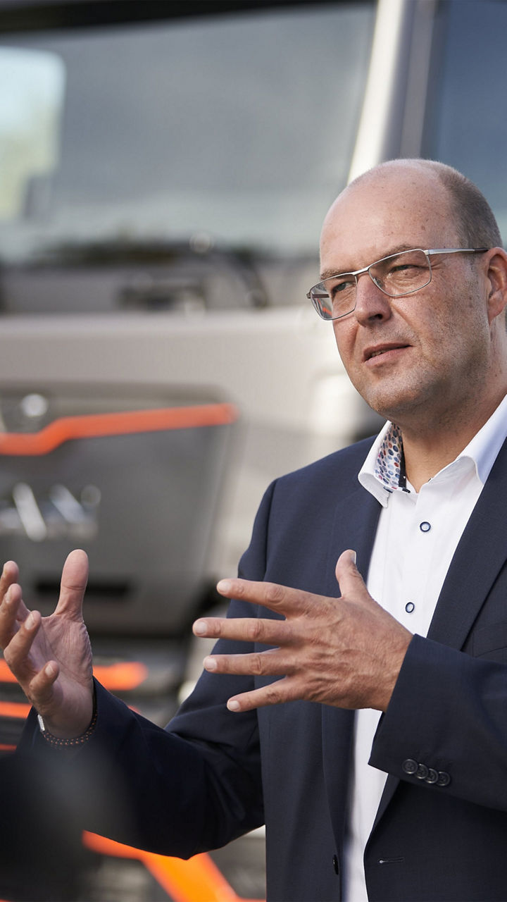 Bernd Reining steht vor dem eTruck und gestikuliert