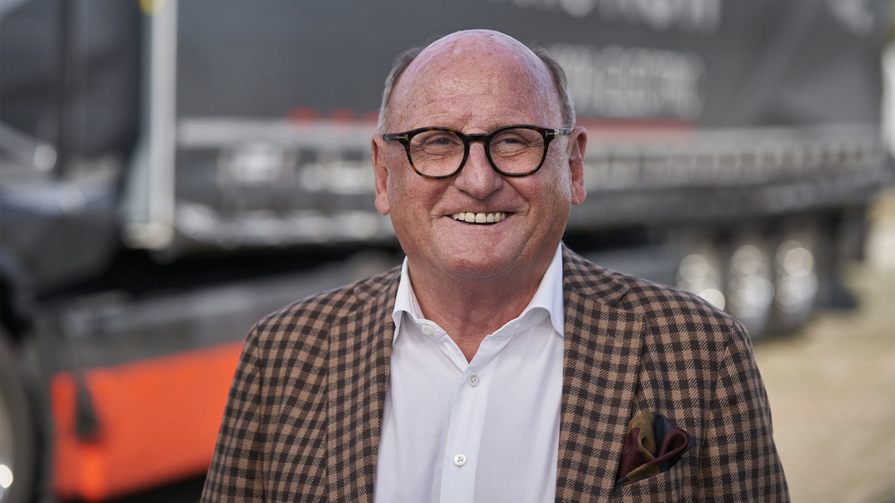 Rudolf Ebner steht vor dem MAN eTruck und schaut in die Kamera