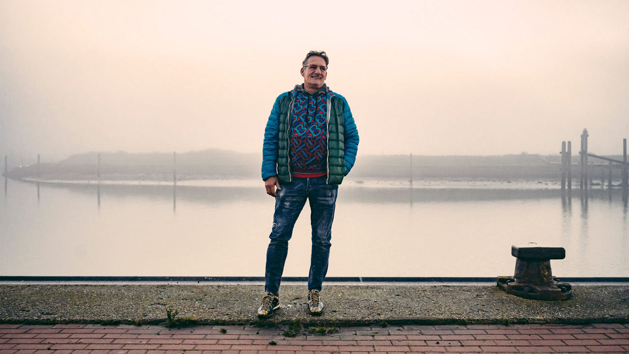 Portrait von Spediteur Georg Fischer, der lächelnd am Hafen steht. 