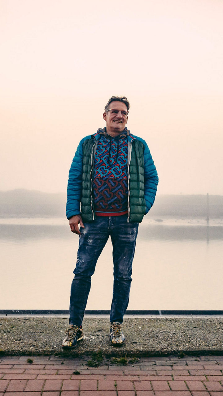 Portrait von Spediteur Georg Fischer, der lächelnd am Hafen steht. 