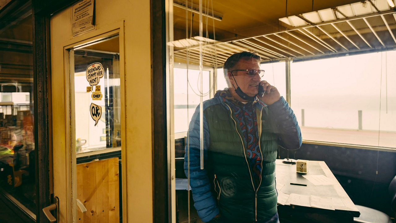 Eine Person steht in einem Kabuff und telefoniert. 