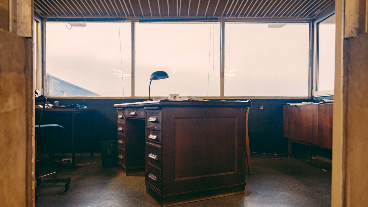 Blick ins Speditionsbüro, in dem ein alter Sekretär steht. 