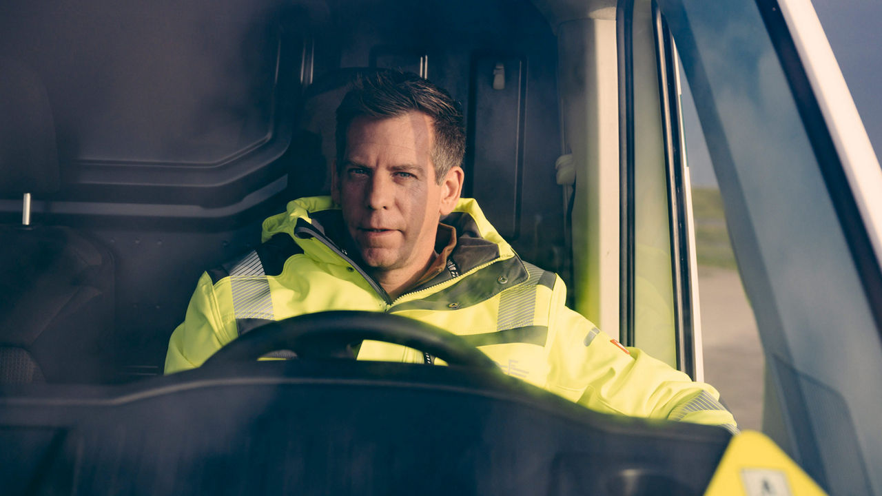 Sven Große-Hohnacker hinter dem Lenkrad eines Elektrotransporters. 