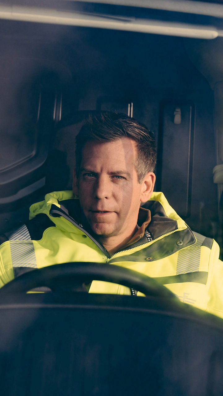 Sven Große-Hohnacker hinter dem Lenkrad eines Elektrotransporters. 