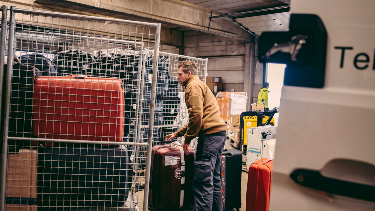 Große-Hohnacker steht in einem Lagerraum, in dem Koffer untergebracht sind. 