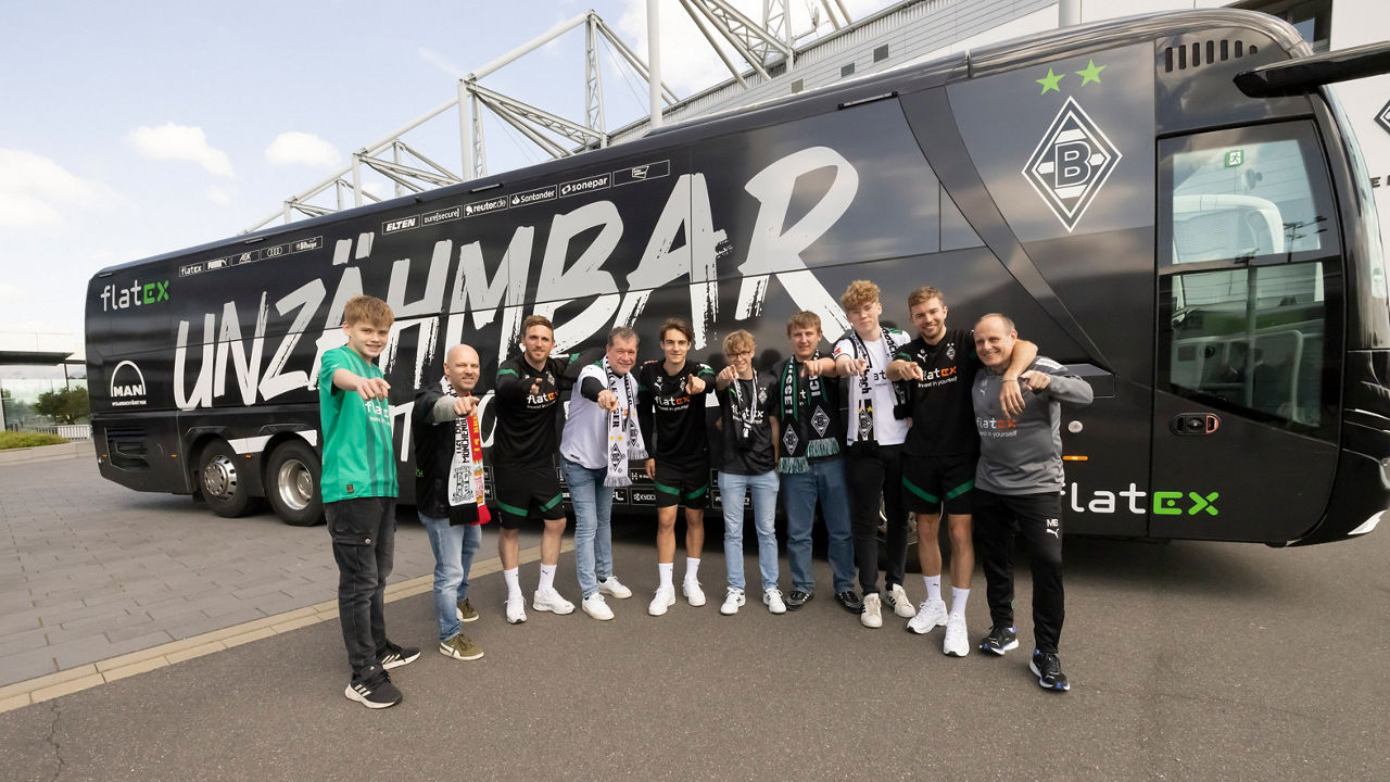 Eine Gruppe Männer steht vor dem Mannschaftsbus von Borussia Mönchengladbach