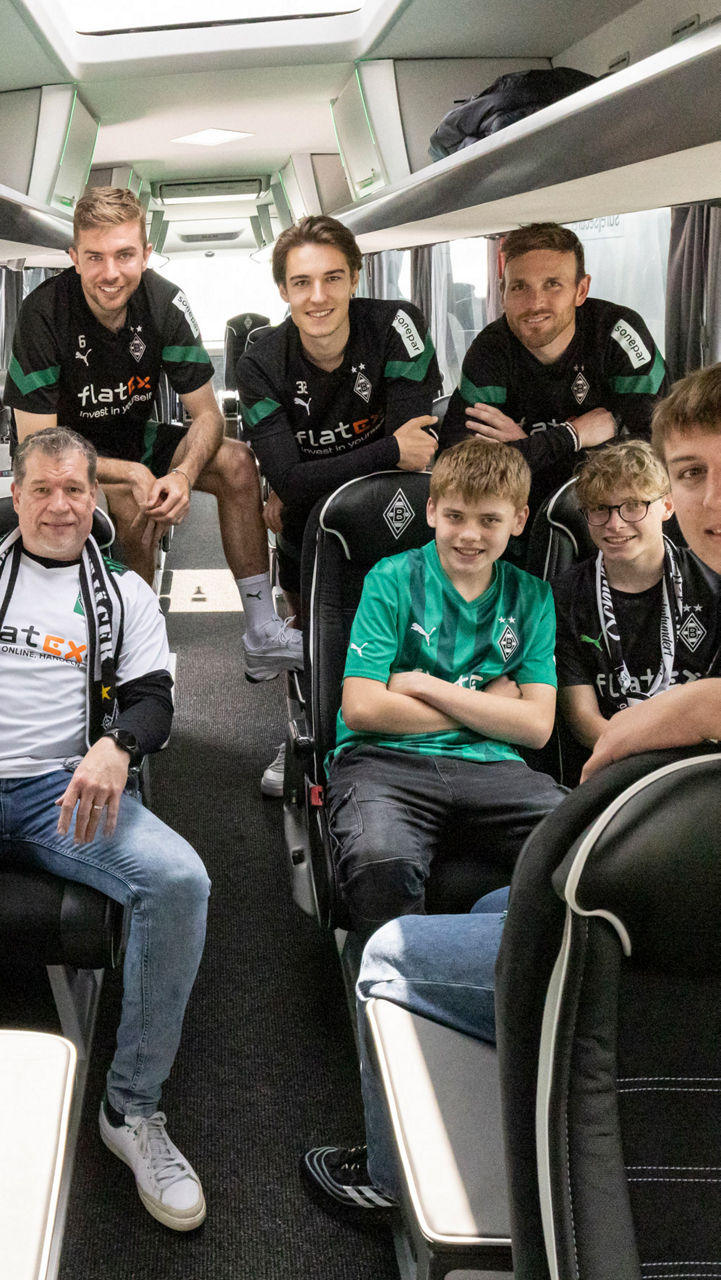 Eine Gruppe Männer und Jungs sitzt in einem Reisebus