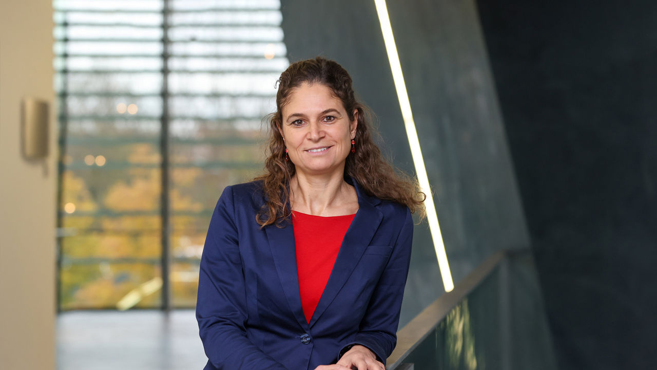 Nicole Rostock leaning against a railing and looking into the camera