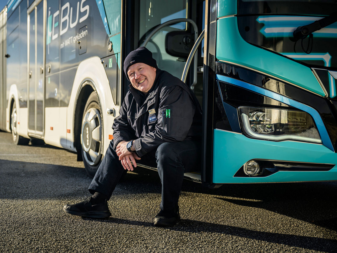 Ein Mann sitzt in der Tür eines E-Busses
