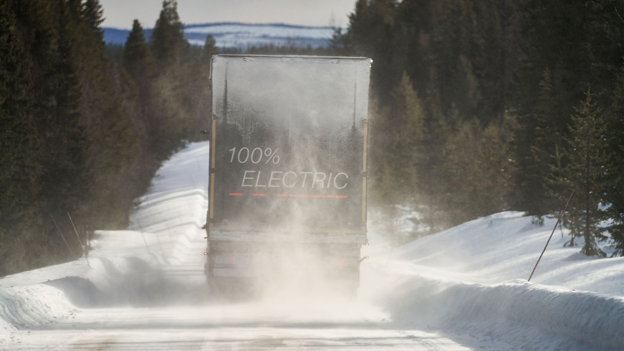 A MAN truck drives through a winter landscape. 