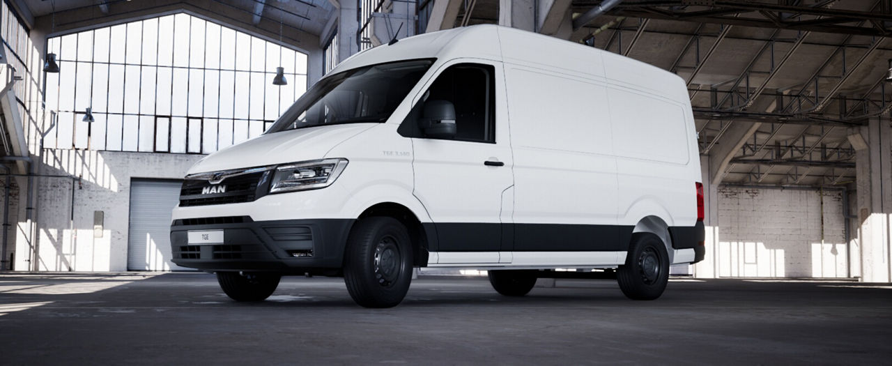 Side view of a white MAN panel van in a spacious warehouse setting.