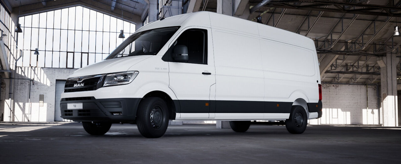 Side view of a white MAN high-roof delivery van in a large indoor hall