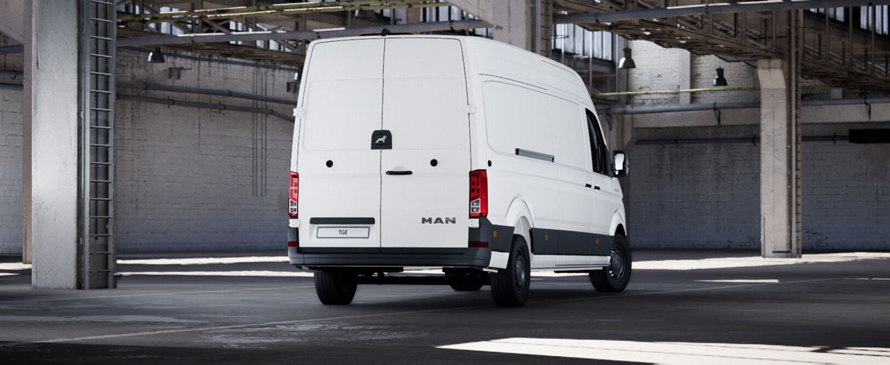 Rear three-quarter view of a white MAN panel van parked indoors