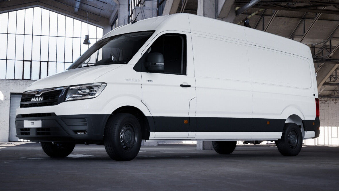 Side view of a white MAN high-roof delivery van in a large indoor hall