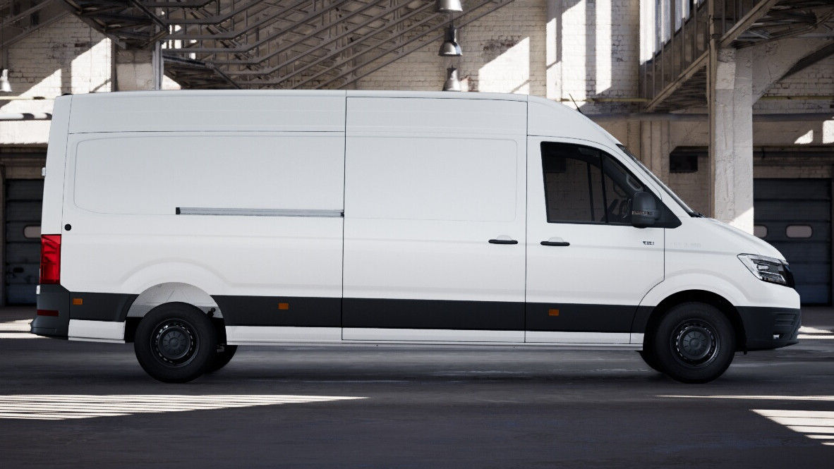 Full lright-side profile of a white MAN panel van in an industrial building