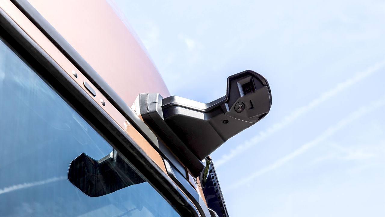 MAN TGX спереду їде по дорозі з темними хмарами на тлі.