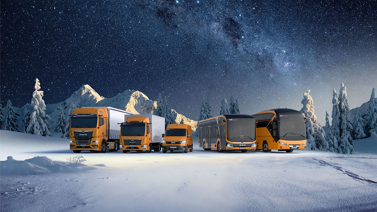 MAN TopUsed trucks, vans and buses in a snowy winter landscape under a starry sky.