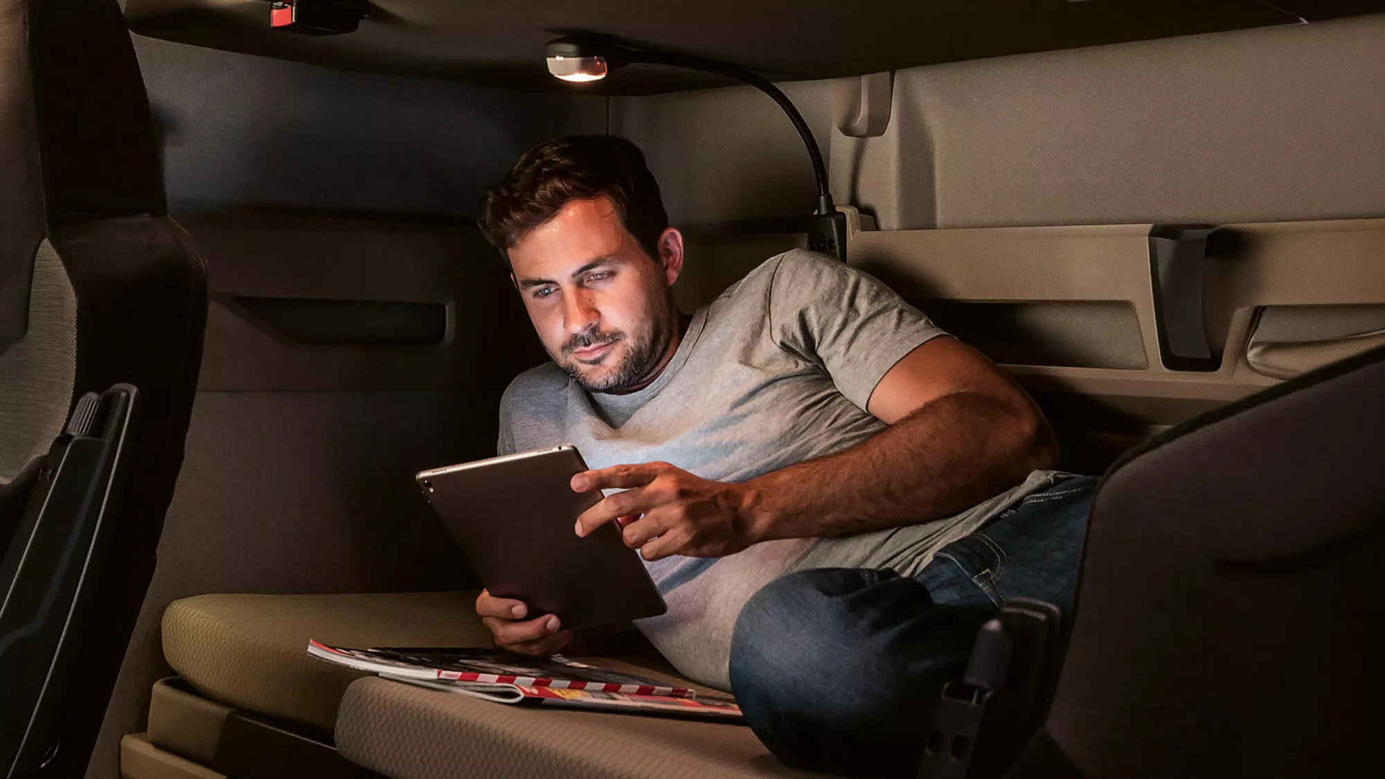Mann liegt mit Tablet im Truck