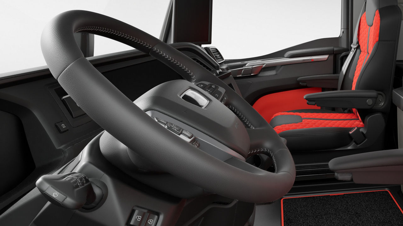 Leather steering wheel with red decorative stitching.