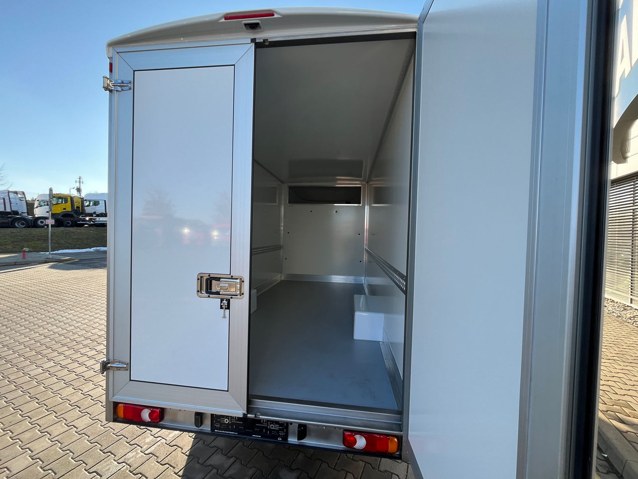 Full lright-side profile of a white MAN panel van in an industrial building