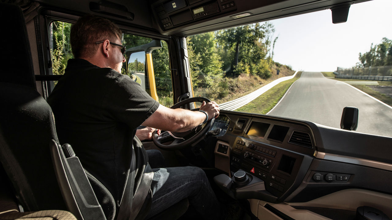 Lkw-Fahrer steuert seinen Truck auf einer bergauf führenden Straße