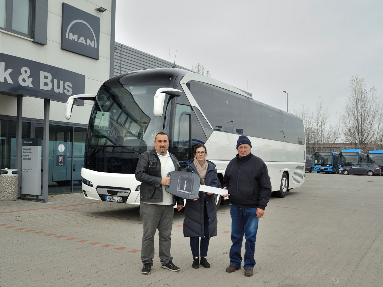 Három személy egy Neoplan busz előtt