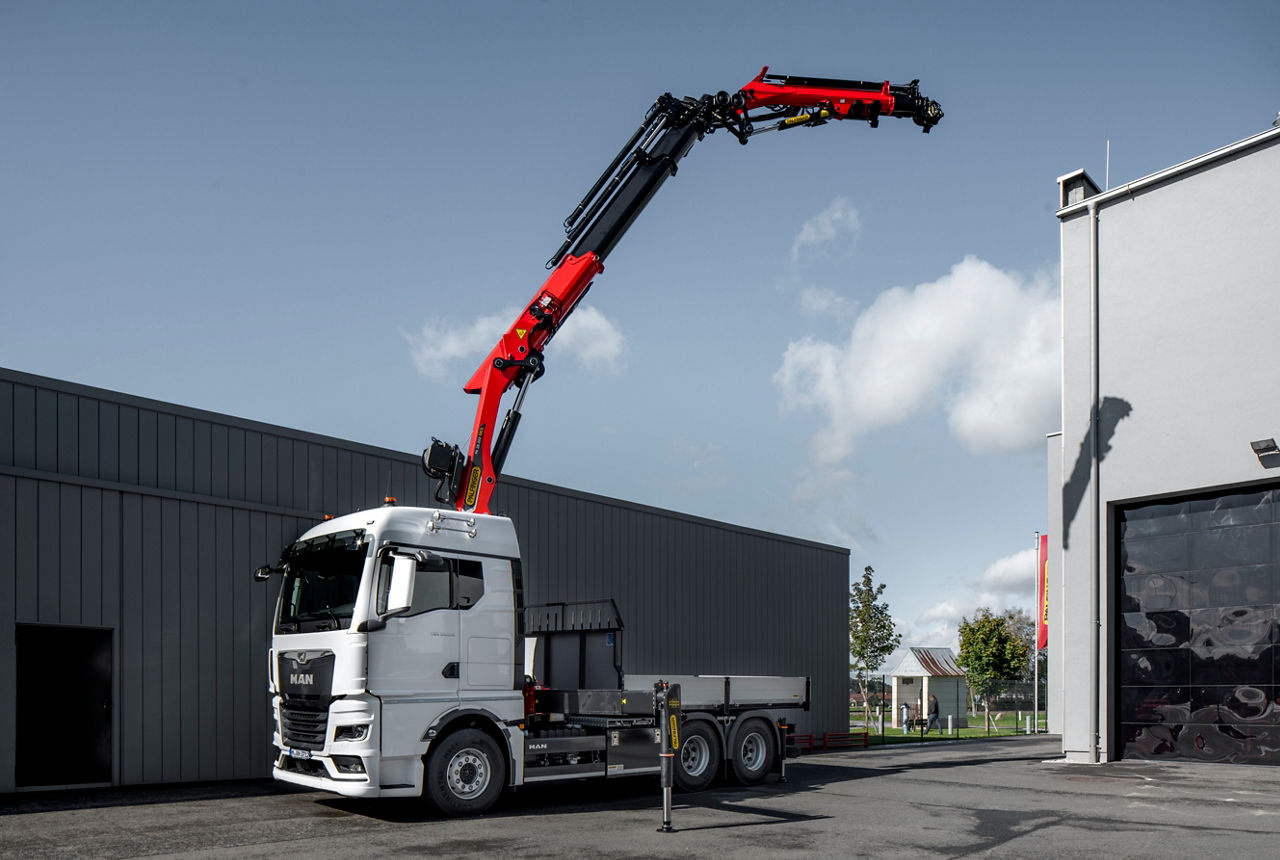 The MAN TGX 33.510 6x4 with GM cab has been fitted with a heavy duty loading crane with four supports by the body manufacturer; on the front of the crane and at the rear directly on the frame behind the rear axles.DE: Der MAN TGX 33.510 6x4 mit GM-Fahrerhaus erhielt vom Aufbauhersteller einen schweren Ladekran mit einer Vierfach-Abstützung: vorne am Kran und hinten direkt am Rahmen hinter den Hinterachsen.UK: The MAN TGX 33.510 6x4 with GM cab has been fitted with a heavy duty loading crane with four supports by the body manufacturer; on the front of the crane and at the rear directly on the frame behind the rear axles