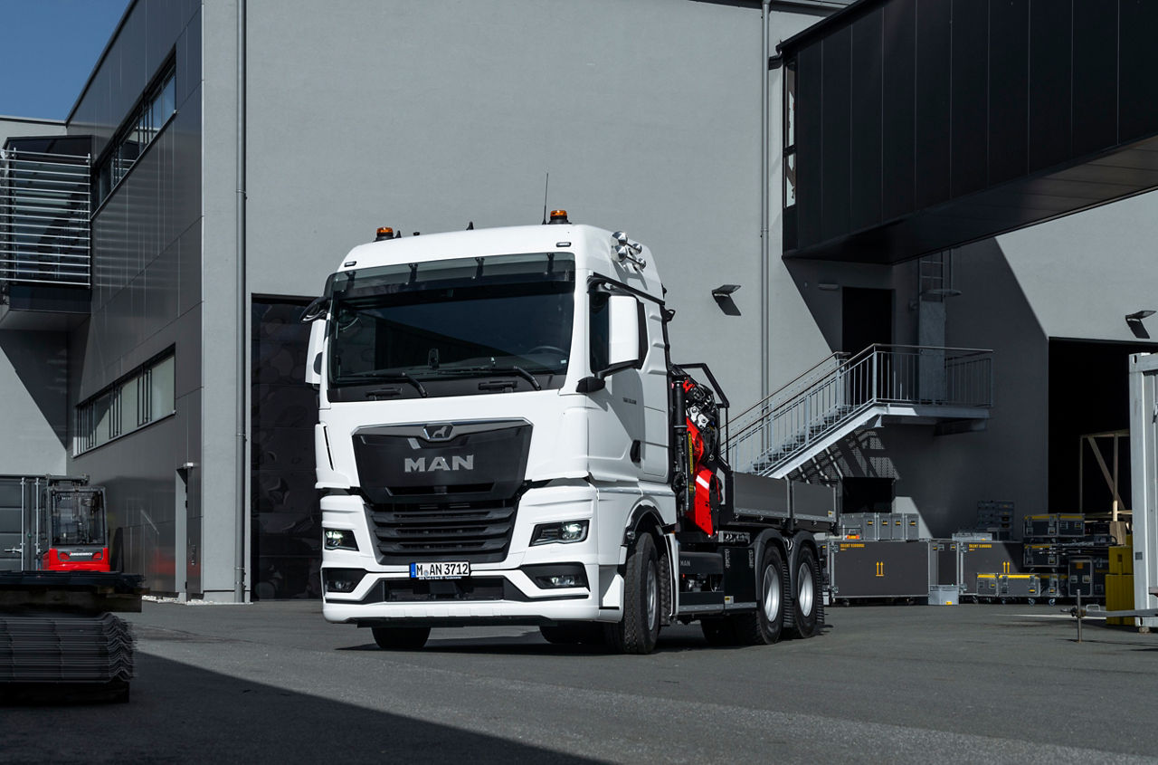 In driving position, the heavy duty loading crane on the MAN TGX 33.510 6x4 is inconspicuous. The lifting accessories and crane attachments can be transported within easy reach in the loading area. DE: In Fahrstellung fällt der schwere Ladekran auf dem MAN TGX 33.510 6x4 nicht auf. Auf der Ladefläche lassen sich die Anschlagmittel und Krananbaugeräte griffbereit transportieren.UK: In driving position, the heavy duty loading crane on the MAN TGX 33.510 6x4 is inconspicuous. The lifting accessories and crane attachments can be transported within easy reach in the loading