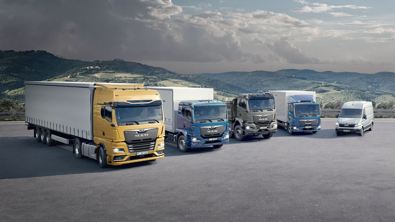 MAN vehicles lined up in front of an alpine landscape
